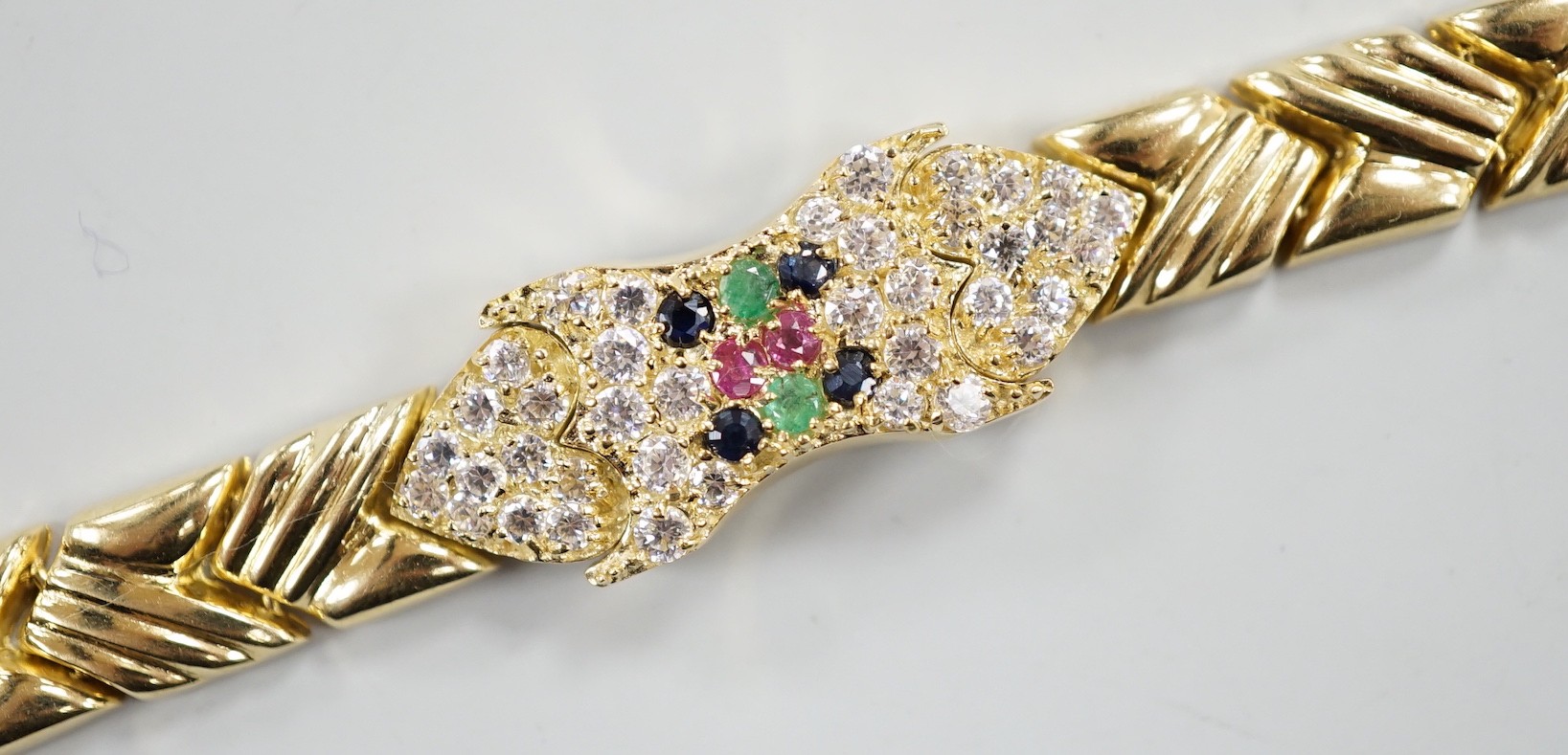 A modern 585 yellow metal, ruby, sapphire, emerald and diamond cluster set bracelet, 17.5cm, gross weight 18.9 grams.